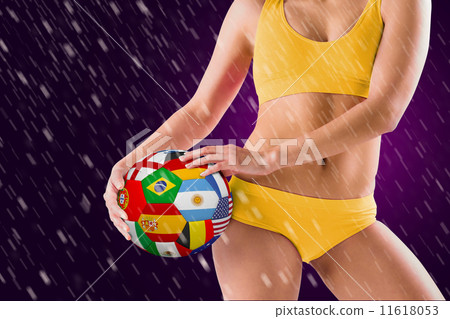 Composite image of fit girl in yellow bikini holding flag footba 11618053