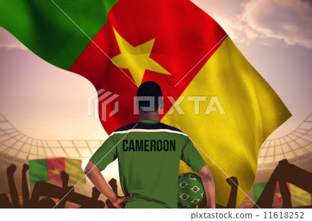 Composite image of cameroon football player holding ball 11618252