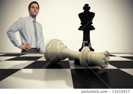 Composite image of serious businessman with hand on hip 11618427