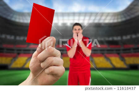 Composite image of hand holding up red card to player Composite image of hand holding up red card to player 11618437