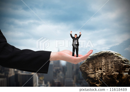 Composite image of businessman cheering at the camera in large h 11618489