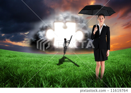Composite image of young businesswoman holding umbrella 11619764