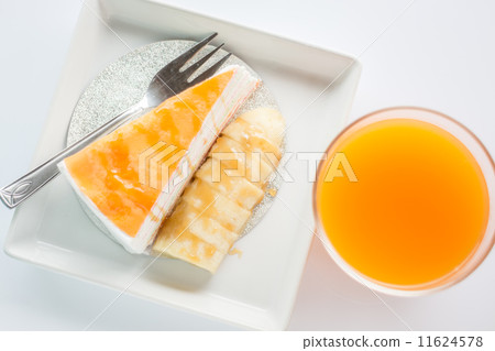 Top view of banana caramel crepe cake and orange juice on white 11624578