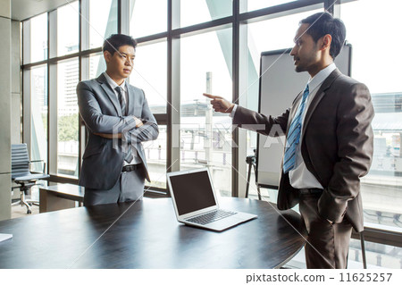 Businessman and colleague arguing in meeting room 11625257