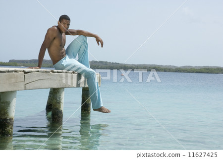 Hispanic man sitting on dock 11627425