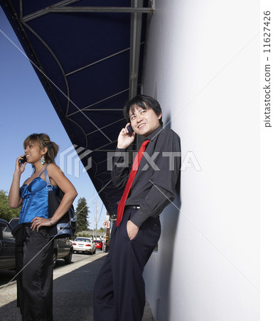 Asian couple talking on cell phones 11627426