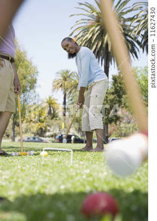 Mixed Race woman playing croquet Mixed Race woman playing croquet 11627430