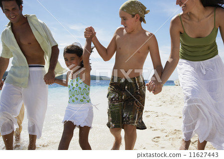 Hispanic family holding hands at beach 11627443