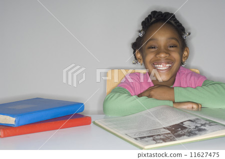 African girl at table with school books African girl at table with school books 11627475
