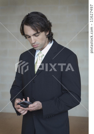 Businessman looking at electronic organizer 11627497