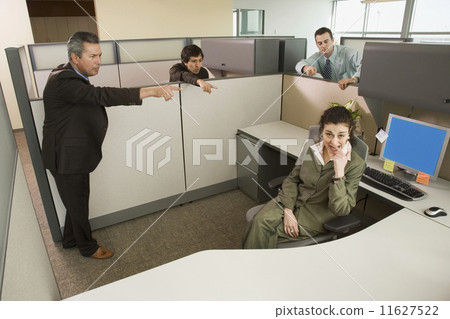 Stock Photo: Businesspeople pointing at co-worker in office cubicle