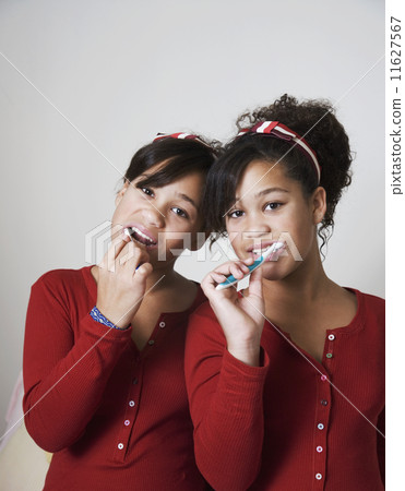 African twin sisters brushing teeth 11627567