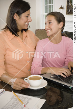 Hispanic mother and daughter smiling at each other 11627614