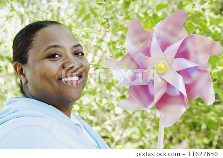 African woman holding pinwheel outdoors African woman holding pinwheel outdoors 11627630