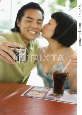 Asian couple taking own photograph 11627639