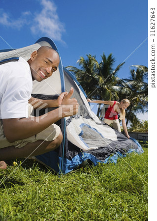 Stock Photo: Multi-ethnic couple setting up tent