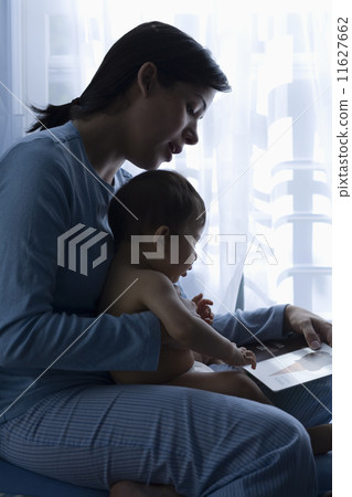 Mother reading to baby Mother reading to baby 11627662