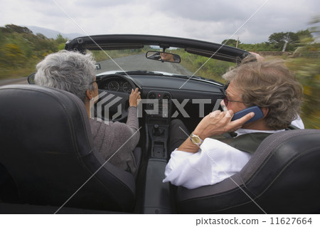 Senior couple driving in convertible car Senior couple driving in convertible car 11627664