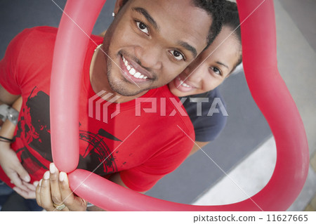 African couple holding heart-shaped balloon 11627665