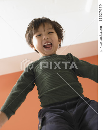 Young boy jumping on bed 11627679