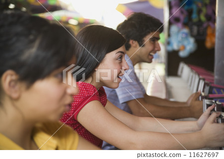 Multi-ethnic teenaged friends playing carnival game 11627697