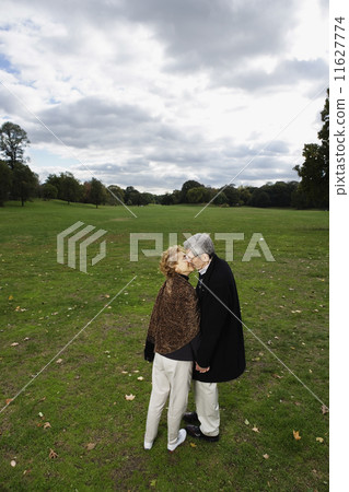 Senior couple kissing in open meadow Senior couple kissing in open meadow 11627774
