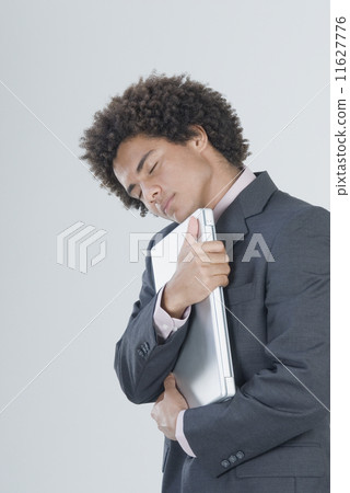 Mixed Race businessman hugging laptop 11627776