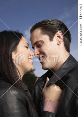 Multi-ethnic couple hugging outdoors 11627801