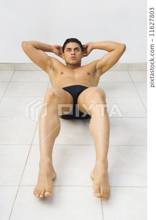 Bare-chested Hispanic man doing sit-ups 11627803