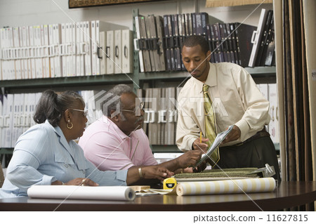 African American couple looking at flooring samples 11627815
