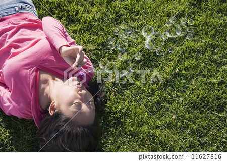 Asian woman blowing bubbles 11627816