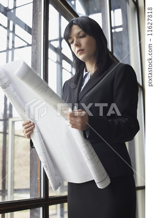 Businesswoman looking at blueprints Businesswoman looking at blueprints 11627818