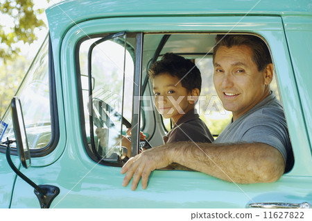 Hispanic father and son sitting in truck 11627822
