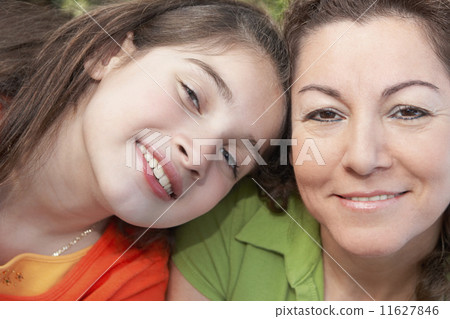 Hispanic girl leaning on mother's shoulder 11627846