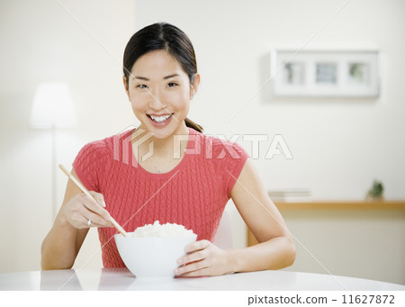 Asian woman eating bowl of rice Asian woman eating bowl of rice 11627872