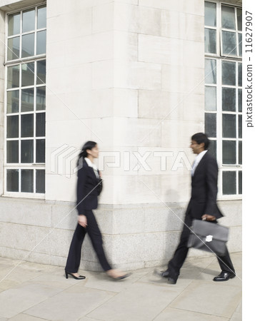Multi-ethnic businesspeople walking around corner 11627907