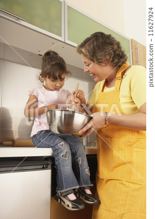 Mother and daughter cooking together Mother and daughter cooking together 11627924