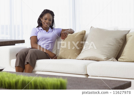 African American woman sitting on sofa 11627978