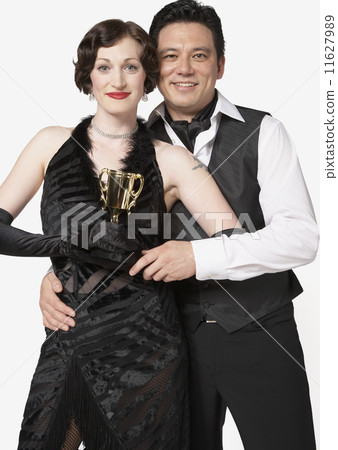Multi-ethnic couple holding tango trophy 11627989
