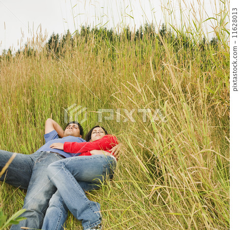 Indian couple laying in tall grass Indian couple laying in tall grass 11628013