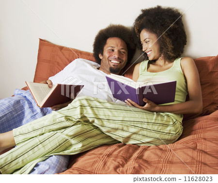 African couple reading in bed 11628023