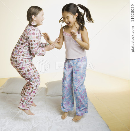 Two girls jumping on bed Two girls jumping on bed 11628039