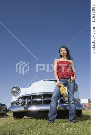 Mixed Race woman in front of low rider car 11628099