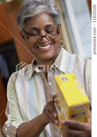 African woman reading food ingredients 11628100