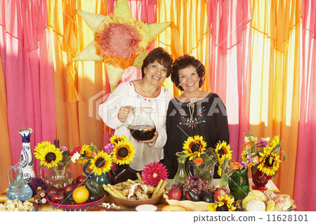Senior Hispanic women behind buffet table 11628101