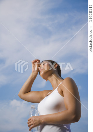 Hispanic woman holding water bottle 11628112