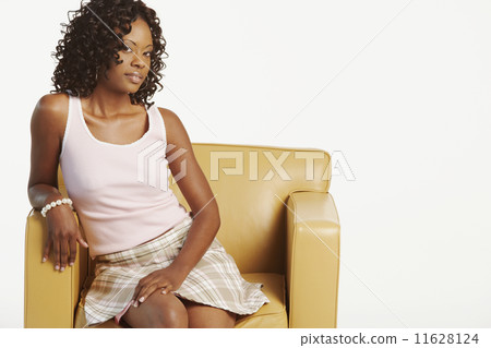 Studio shot of African woman in armchair Studio shot of African woman in armchair 11628124