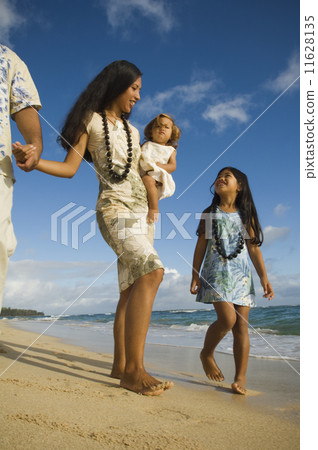 Pacific Islander family walking on beach 11628135