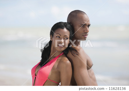 Multi-ethnic couple standing back to back 11628136