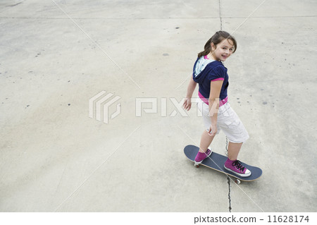 Mixed Race girl riding skateboard Mixed Race girl riding skateboard 11628174